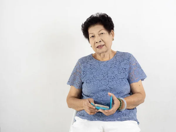 Asiatische Seniorin benutzt Smartphone zu Hause. — Stockfoto