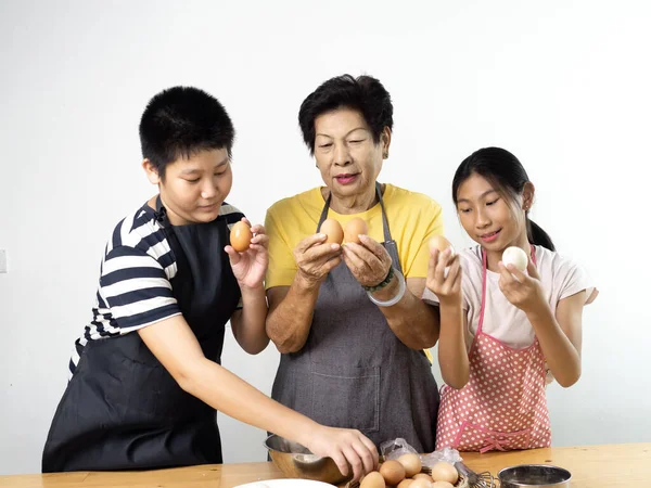 Asiática senior mujer y su nietos mostrando pelado huevos li — Foto de Stock