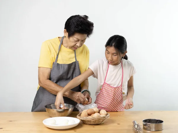 Азиатская старшая женщина технолог внучка для пилинга яиц, стиль жизни — стоковое фото