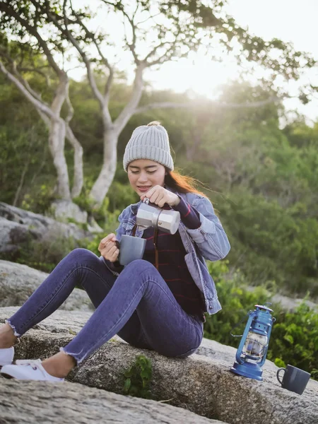 Feliz asiática mujer verter café taza con sol bengala al aire libre . —  Fotos de Stock