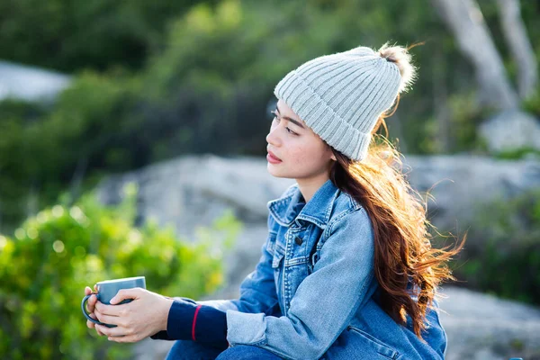 Mujer asiática feliz sosteniendo taza de café con fondo de la naturaleza, leva —  Fotos de Stock