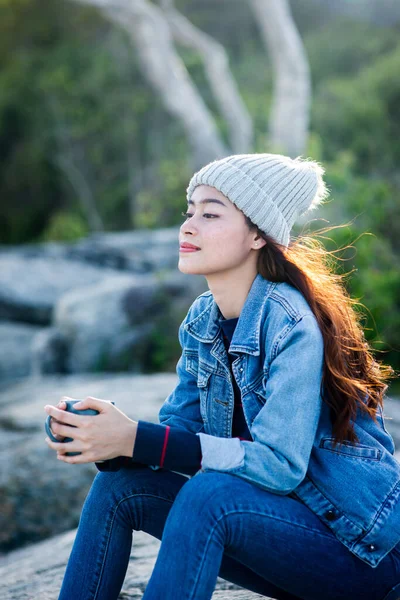 Glücklich asiatische Frau hält Kaffeebecher mit Natur Hintergrund Nocken — Stockfoto