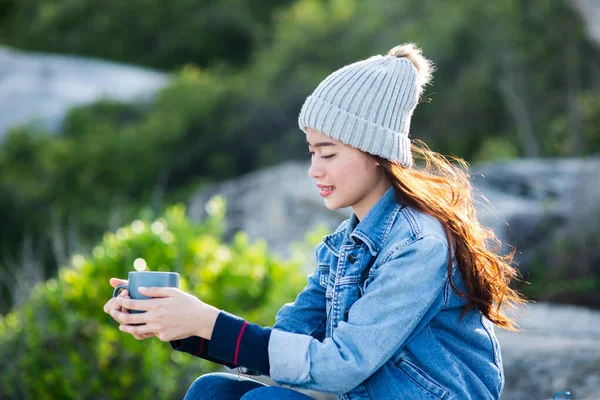 Mujer asiática feliz sosteniendo taza de café con fondo de la naturaleza, leva — Foto de Stock