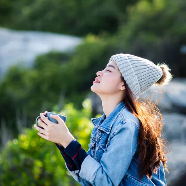 Happy Asian woman holding coffee mug with nature background, cam — Stock Photo, Image