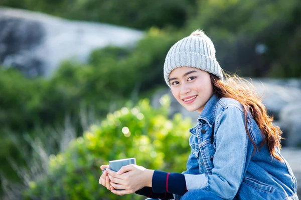 Lycklig asiatisk kvinna innehar kaffekopp med natur bakgrund, Cam — Stockfoto
