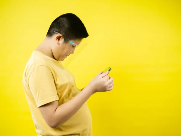 가리개를 착용하고 노란색 스마트폰으로 게임을 아시아 새로운 — 스톡 사진