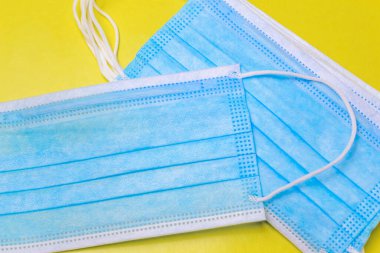 Sarı arka planda birçok tıbbi maske var..