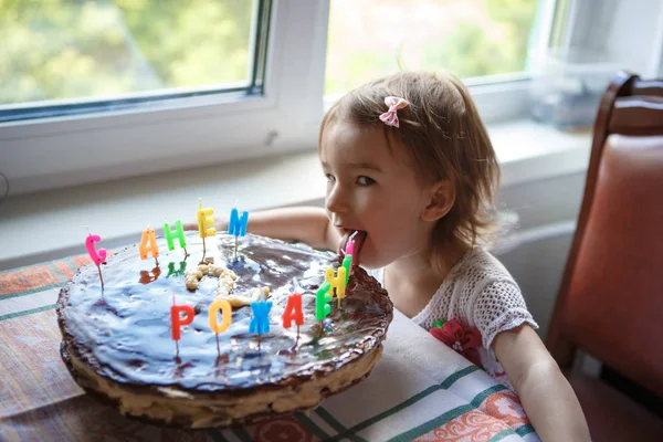 キャンドルでお祝いケーキを食べる女の子 — ストック写真
