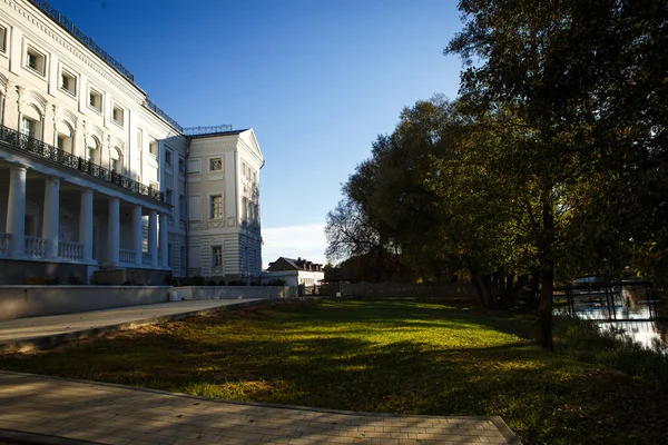 The estate of the Goncharov in Polotnyanyy Zavod. House Museum of Natalia Goncharova, a historical place associated with Pushkin. White walls of a large stone house in autumn, beautiful autumn nature around, white gazebo in the Park