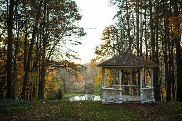 The estate of the Goncharov in Polotnyanyy Zavod. House Museum of Natalia Goncharova, a historical place associated with Pushkin. White walls of a large stone house in autumn, beautiful autumn nature around, white gazebo in the Park