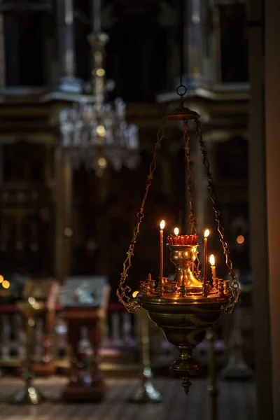 The interior of the Russian Orthodox Church. Candles in the Church, hand holding candle and lights