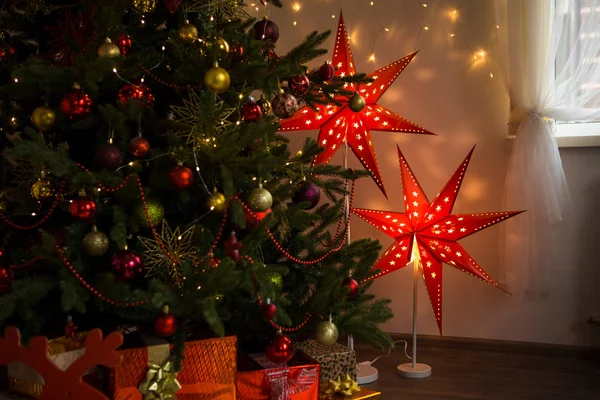 家の中は クリスマスと新年の内部 家のクリスマスの装飾で居心地の良いクリスマス 輝く赤い星 青い椅子 赤い格子縞ライト ガーランドと人工的なクリスマス ツリー — ストック写真