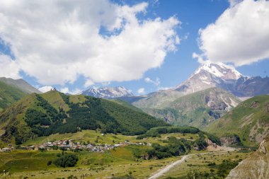 Kamp yerindeki dağın tepesinde bir görünümü ile dağ kampı iç: renkli ahşap çit. Kazbek Dağı ve önündeki Yeşil Vadi.
