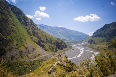 Derin bir geçit, yüksek dağlar ve çimenlerle kaplı tepeler, altta bir dağ Nehri ile kayalık geçit ile dağ yeşili Vadisi. Gürcistan 'ın manzaraları, Gürcü askeri yolu.