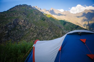 Dağlarda mavi bir turist çadırı duruyor. Açık hava eğlencesi, Georgia 'da yürüyüş.