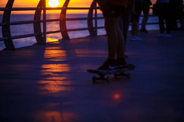 Gente Cammina Lungo Lungomare Nei Raggi Gialli Arancioni Del Sole — Foto Stock