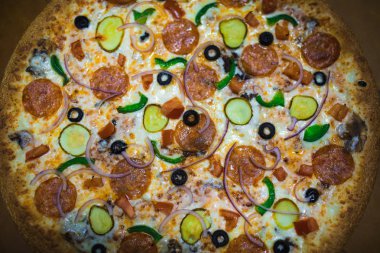 Gri bir arka plan üzerine bir büyük pizza yakın çekim. Renkli pizza tepesi portre