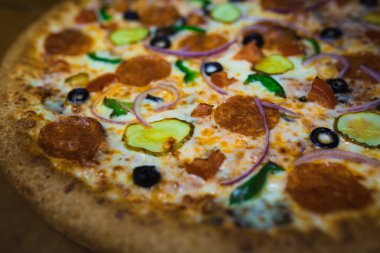 Gri bir arka plan üzerine bir büyük pizza yakın çekim. Renkli pizza tepesi portre