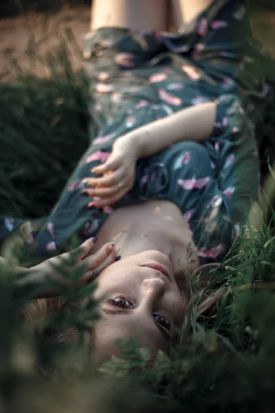 一头长长的金发姑娘躺在草地上 自然界中绿色背景下的金发美女 — 图库照片