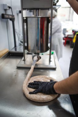 Et ürünlerinin imalatı, eldivenli eller bir çift bağırsak içine kıyma rulo. Et sosis kupata bükülmüş ve güzel yığılmış.