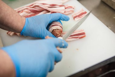 Et ürünlerinin hazırlanması süreci. Eldivenli eller kıyma ve pastırma köftesi kalıplı