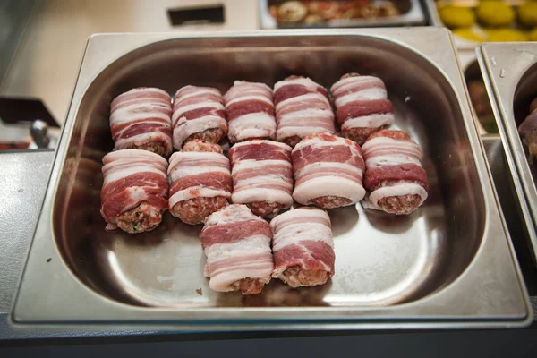 Meat products: cutlets, stuffed cabbage, meatballs in bacon. Fresh appetizing meat store products in metal trays