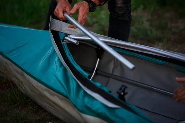 The process of assembling and repairing kayaks: metal skeleton, PVC skin, wooden and aluminum frames. Male hands assemble the canoes and paddle boating. — Stock Image Process Assembling Repairing Kayaks Metal Skeleton Pvc Skin Wooden Aluminum Stock Photo