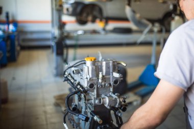 Elinde bir alet ile mekanik makinenin motoru tamir. Servis istasyonunda çalışma süreci