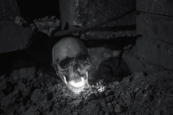 暗い地下の地面の光は内側から黄色になります ハロウィンのための頭蓋骨のレイアウトの恐ろしい画像 — ストック写真