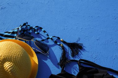 Mavi arka planda bir plaj tatili için kadın aksesuarları. Denize yolculuk konsepti, rahatlama, yüzme, ultraviyole koruma, bronzlaşma. Turizm ve seyahat acentesi. Mesaj için yer. Çerçeve. Düz Yatay