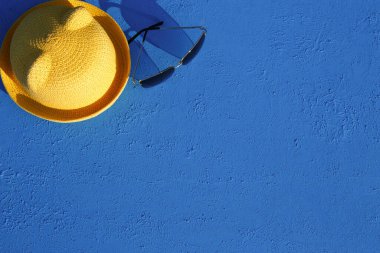 Mavi arka planda bir plaj tatili için kadın aksesuarları. Denize yolculuk konsepti, rahatlama, yüzme, ultraviyole koruma, bronzlaşma. Turizm ve seyahat acentesi. Mesaj için yer. Çerçeve. Düz Yatay