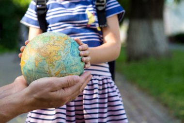 Kaluga, Rusya-23 Haziran 2020. Babası kızına Rusça 'da dünyanın parmağını gösteriyor. İlkokuldan bir kız gezegeni inceliyor. Okula, babalar gününe..