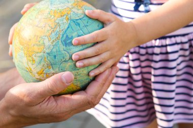 Kaluga, Rusya-23 Haziran 2020. Babası kızına Rusça 'da dünyanın parmağını gösteriyor. İlkokuldan bir kız gezegeni inceliyor. Okula, babalar gününe..