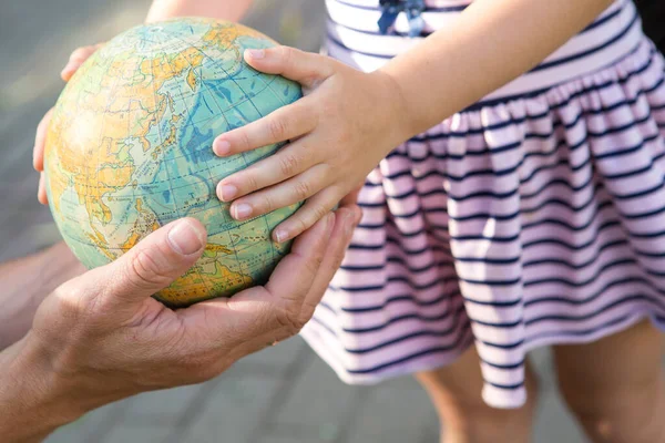 Kaluga, Russia-June 23, 2020. Dad shows his daughter the finger of the country on the globe in Russian. A girl from elementary school is studying the planet. Back to school, father\'s day.