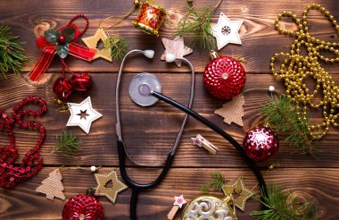 Noel, tıbbi bir tema üzerine kuruluydu. Yıldızlardan, balodan, kurdelelerden, Noel Baba şapkalarından ve bir doktorun steteskopundan yeni yıl için dekorasyonlar. Tahta arkaplan, metin için boşluk