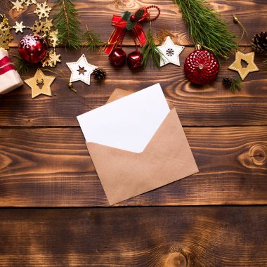El işi kağıdından yapılmış bir zarf, beyaz bir çarşaf ve ahşap bir arka planda Noel dekoru olan bir yazı. Noel Baba 'ya bir mektup, bir dilek listesi, bir yılbaşı hayali, bir hediye. Düz yat, boşluğu kopyala
