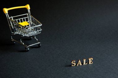 Alışveriş arabası ve siyah arka planda 