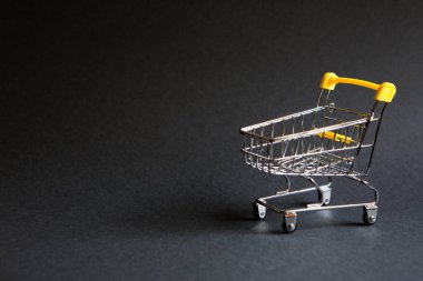 Siyah arka planda süpermarketten alınmış boş bir market arabası. Kara Cuma, alışveriş arabası, alışveriş, online mağaza, indirim. Metin için boşluk