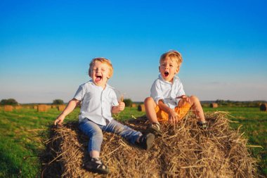 İki küçük çocuğu alan ve gülmek samanlıkta oturmak