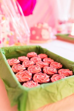 Pembe şeker kaplı fincan kek yeşil sepet ve arka plan bulanık