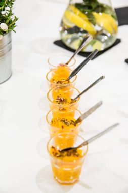 Mango Mousse beyaz masada küçük tatlı bardaklarda