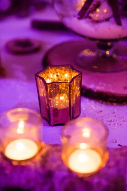 Ahşap düğün masa dekorasyonu mum ve mor aydınlatma