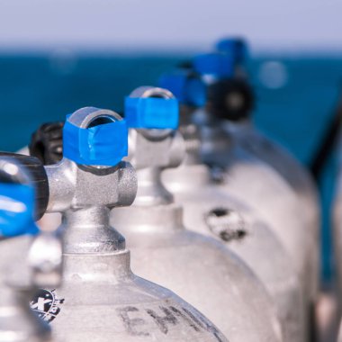Mavi bant ve deniz içinde belgili tanımlık geçmiş ile tüplü dalış tankları