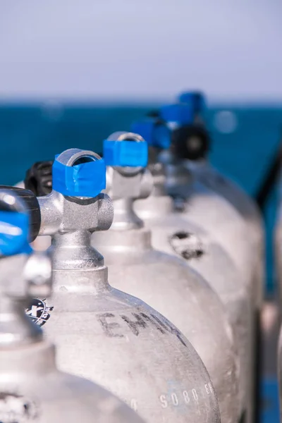 Scuba Diving Tanks with Blue Tape and Sea in the Background