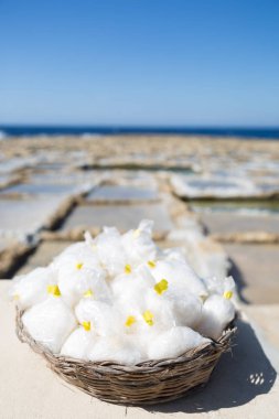 Gozo Island Natural Sea Salt basket with Salines and Blue Sea in the Background clipart