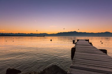 Leman Gölü ve donmuş iskele üzerinde şafakta uçan martılar