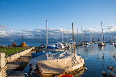 Alps içinde belgili tanımlık geçmiş ile gün batımında tekne ve Leman Gölü üzerinde Marina demirleme