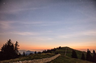 Yıldızlı gece gökyüzü ve kayan yıldız Dağları üzerinde