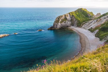 Batı Lulworth Cove güneşli bir kumsalda savaş adamı