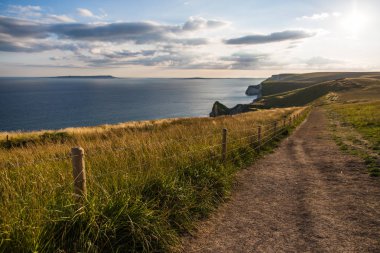 Lulworth koyu sahil yolu ve haddeleme Cliffs at Sunset